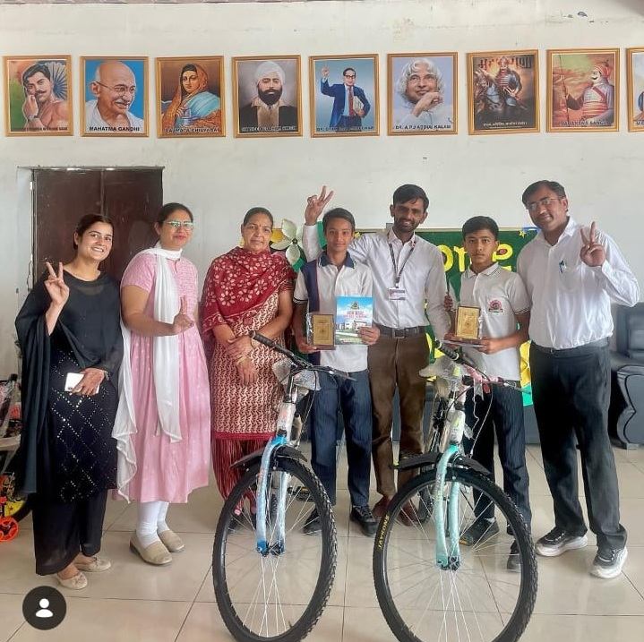 Students awarded bicycles and trophies by their teachers