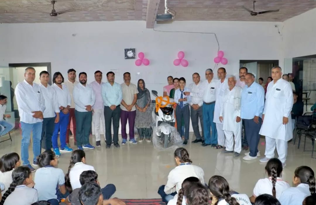 Board topper receiving a scooty award in front of guests and students